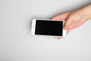 hafif bir arka plan üzerinde elinde telefon