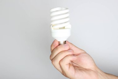enerji tasarruflu ampul elinde hafif bir arka plan üzerinde