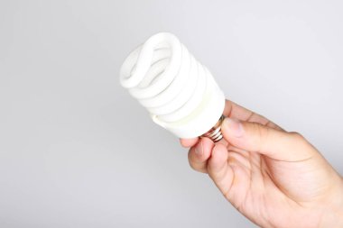 enerji tasarruflu ampul elinde hafif bir arka plan üzerinde