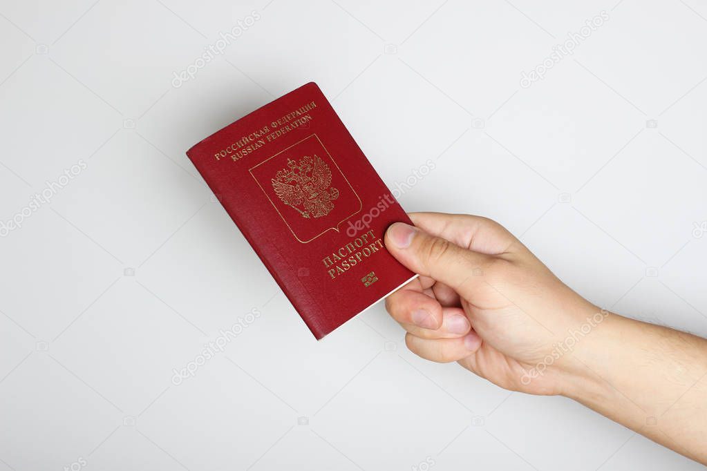 Passport in hand on a light background