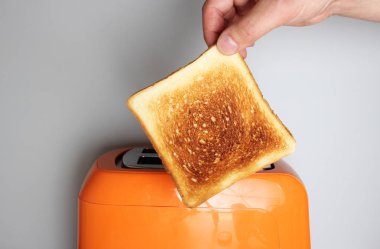 El tost ve hafif bir arka plan üzerinde turuncu ekmek kızartma makinesi