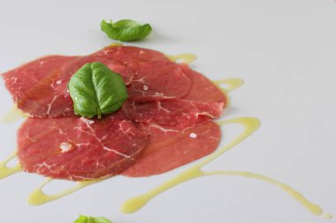 Dana carpaccio ışık gri fesleğen arka plan üzerinde