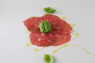 Dana carpaccio ışık gri fesleğen arka plan üzerinde