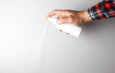 Gri arka planda elinde sprey tabanca