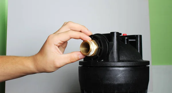 setting a water filter hand holding a blue flask on a light background