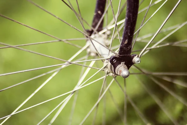 緑の背景に古いレトロな自転車ホイール スポークのクローズ アップ — ストック写真