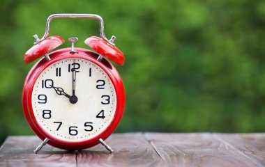 Fotokopi alanı, gün ışığı tasarrufu, zaman yönetimi, son teslim tarihi kavramına sahip ahşap bir arkaplan üzerindeki geri alarm saati