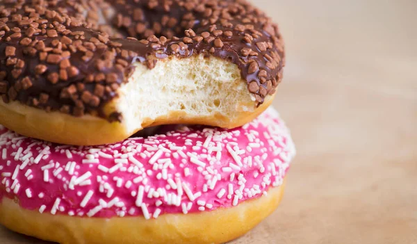Unhealthy eating, junk food concept, sweet bitten chocolate and pink donut with copy space