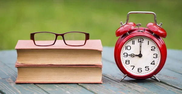 Back to school time, learning concept, retro alarm clock, books and eyeglasses in the morning, web banner