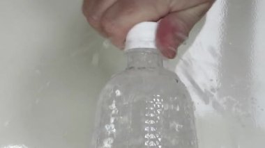 Erkek El bir şişe köpüklü su açar.