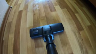 POV yerde bir elektrikli süpürge hareketi yapıyor. Yerleri süpüren süpürge..
