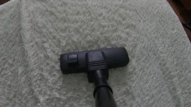 POV koltuğun üzerinde elektrikli süpürge hareketi yapıyor. Kanepeyi temizleyen süpürge..