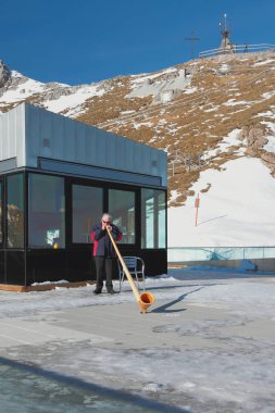 Pilatus, Lucerne, İsviçre - 08 Ocak 2013: Dağlarda Alp boynuzu olan adam