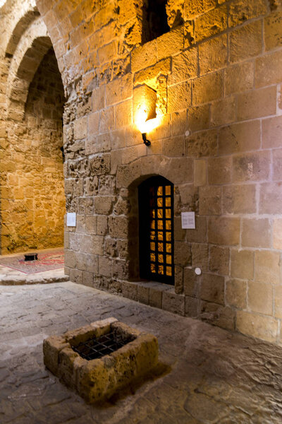 An inside arched hall and a former prison cell in Paphos Castle museum, Cyprus