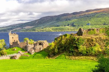 Doğal görünümü bir tekne yaklaşıyor, İskoçya, Loch Ness yatay ve İskoç bir bayrak sitesiyle Urquhart Castle