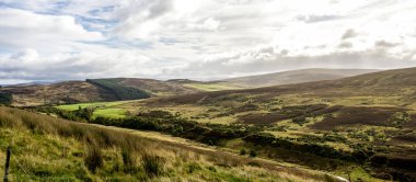 İskoçya 'daki Cairngorms Ulusal Parkı' nda küçük tepelerle çevrili küçük bir vadinin manzaralı renkli manzarası.