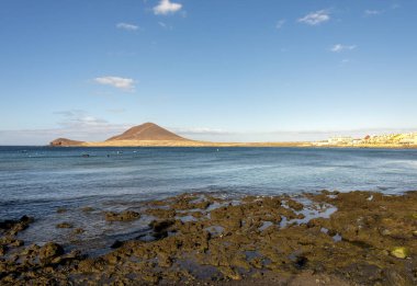 İspanya 'nın Tenerife kentindeki El Medano kasabası yakınlarındaki Roja Dağı ve Play de Leocadio Machado plajının uzak bir manzarası.