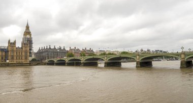Brown dirty waters of river Thames at Westminster bridge and Big Ben tower, London, England clipart