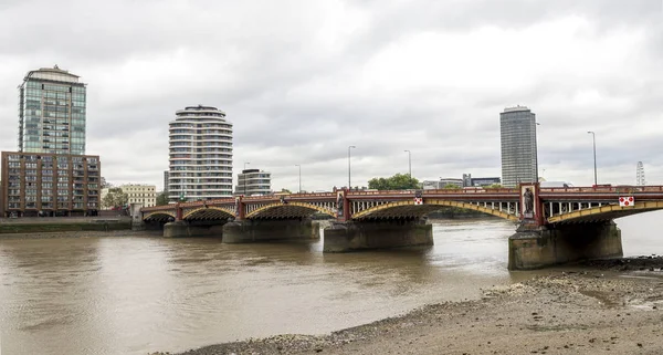 Vauxhall traffic and footbridge and dirty shore of river Thames, Londres, Inglaterra —  Fotos de Stock