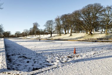 Duthie Park, Aberdeen, İskoçya girişinde bir ara sokak ve karla kaplı büyük boş bir gölet.