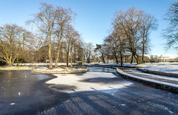 Un pequeño estanque congelado cerca del césped cental y el cenador escénico en Duthie Park, Aberdeen, Escocia — Foto de Stock