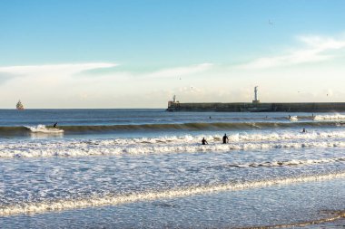 Birçok sörfçü İskoçya 'nın Aberdeen plajında güneşli bir kış havasının tadını çıkarır.