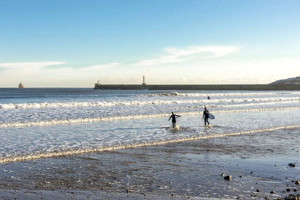 Quelques surfeurs pénètrent dans l'eau sur la plage d'Aberdeen près du brise-lames sud, en Écosse — Photo