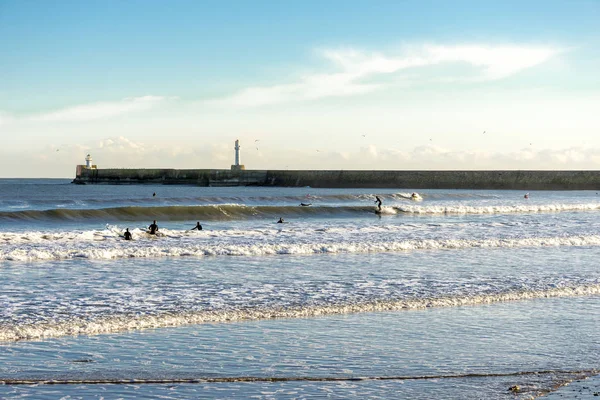 Personnes vagues de surf près phare brise-lames sud, plage d'Aberdeen, Écosse — Photo