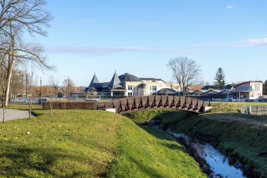 Macaristan 'ın güneşli bir gününde Szigetvar termal kaplıca merkezi yakınlarındaki bir derenin üzerindeki küçük, manzaralı kemerli bir köprü.