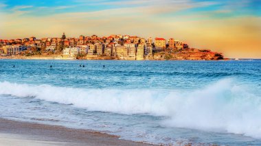 Bondi Plajı ve turuncu günbatımı karşı kıyıdaki binalar