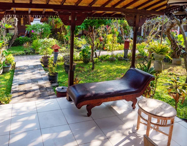 Yemyeşil yeşil garde Endonezya bir bungalow verandada Divan