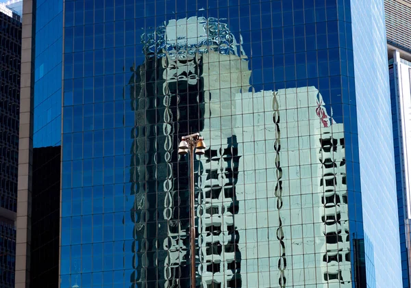 Reflecties in de blauwe ramen van een hoog kantoorgebouw — Stockfoto