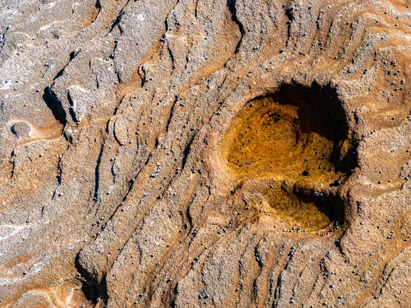 Los cachorros pequeños y la formación redonda rocosa en la playa — Foto de Stock