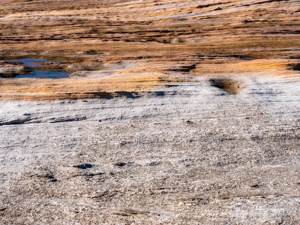 La superficie gris y anaranjada de la roca en la playa — Foto de Stock