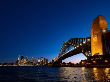 Karanlık gökyüzüne karşı geceleri Harbour Bridge ve Sydney şehir silueti