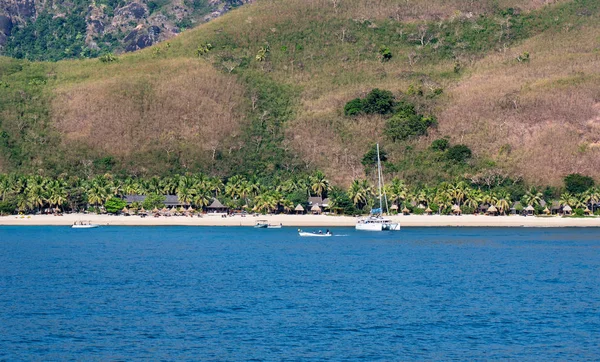 Resort auf einer tropischen Insel mit einem Hügel im Hintergrund Stockbild