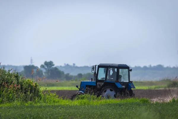 拖拉机工作在农场 现代农业运输 农夫在领域工作 拖拉机在日落背景下 耕种土地 农业机械 — 图库照片