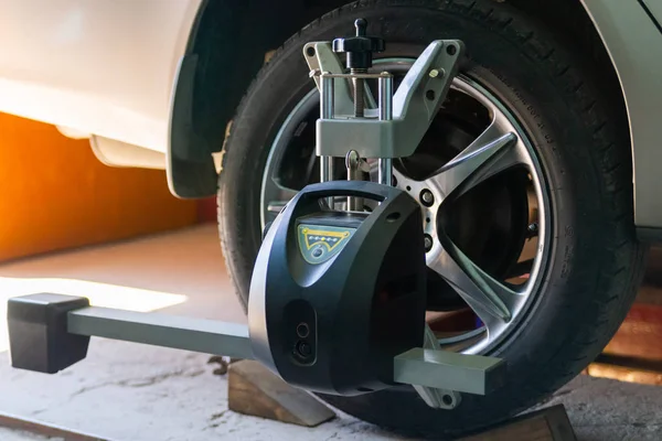 Car on stand with sensors on wheels for wheels alignment camber check in workshop of Service station.