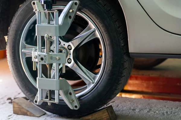 Tekerlekler hizalama kamber için gezici sensörleri ile stand arabayı kontrol servis istasyonu atölyesinde.