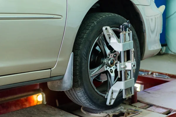 Tekerlekler hizalama kamber için gezici sensörleri ile stand arabayı kontrol servis istasyonu atölyesinde.