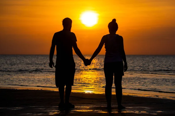 Gündoğumu eliyle tutarak aşık çift.