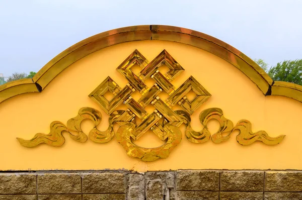Golden endless knot sign on buddhist temple.