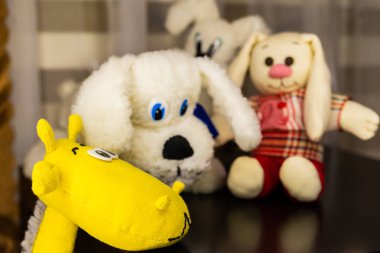 Sarı zürafa namlu tablodur. Arka planda yumuşak oyuncaklar.