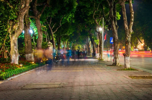 Shady walkway with tropical trees at street of Hanoi at evening. Long exposure shot.