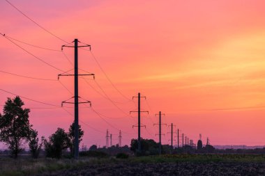 Gün batımında yüksek voltajlı kırsal alan. Dramatik gökyüzü görünümü