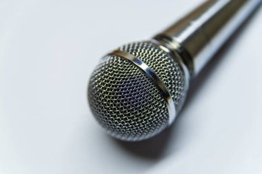 Beyaz arkaplan yüzeyinde gümüş ses mikrofonu.