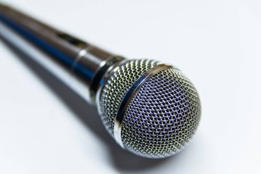 Beyaz arkaplan yüzeyinde gümüş ses mikrofonu.