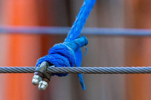 Steel and synthetic ropes connected by loose straps.
