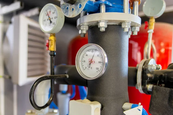 The equipment of the boiler-house, valves, tubes, pressure gauges, thermometer. Close up of manometer, pipe, flow meter, water pumps and valves of heating system in a boiler room.
