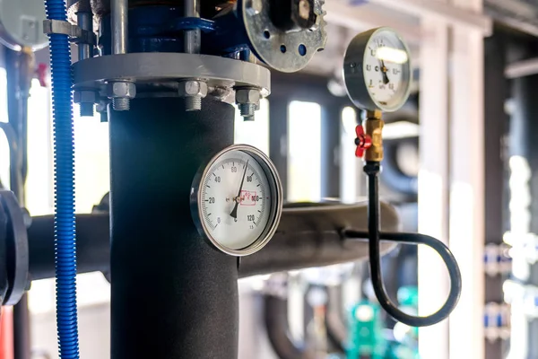 The equipment of the boiler-house, valves, tubes, pressure gauges, thermometer. Close up of manometer, pipe, flow meter, water pumps and valves of heating system in a boiler room.